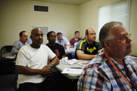Men of different ages and racial backgrounds participating in a small focus group watch a presentation
