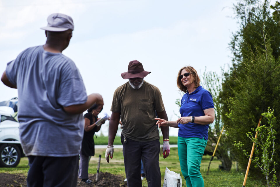 Three people working together in a garden.
